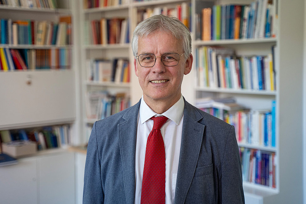 Porträt eines KAG-Vorsitzenden in Büro mit Bücherregal