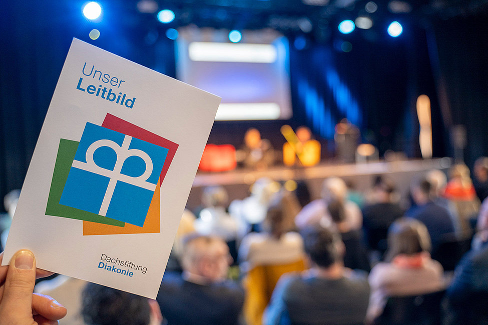 Broschüre Unser Leitbild der Dachstiftung Diakonie vor Publikum